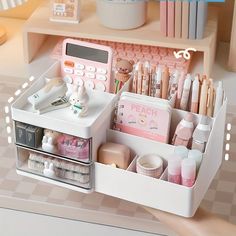 an organized drawer with various items in it on a countertop next to a shelf