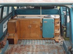 the interior of an old blue truck with a stove and refrigerator in it's back