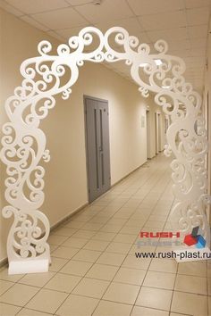 an arch in the hallway is decorated with white swirls and scrolls on it's sides