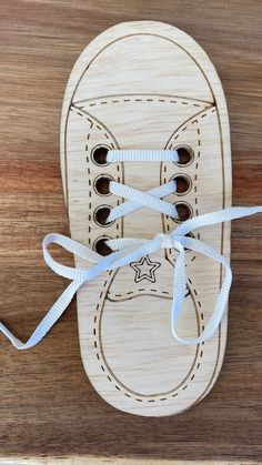 a wooden shoe with white laces tied to it on top of a wood surface