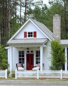 a small white house with red shutters