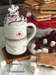 a cup of hot chocolate with marshmallows and graham crackers on the side