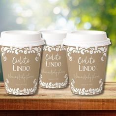 three coffee cups sitting on top of a wooden table