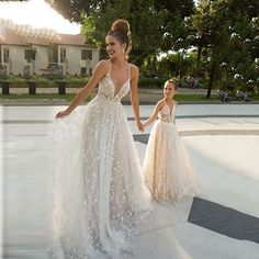 two women in wedding dresses walking down the street