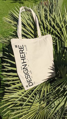 a white bag sitting on top of a palm tree next to a green grass covered field