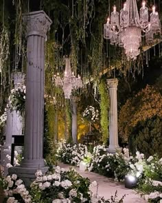 an elaborate garden with chandeliers and white flowers in the foreground, surrounded by greenery