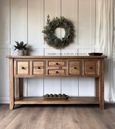 a wooden table with drawers and a wreath on top