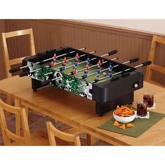 a foosball table set up with chips and drinks