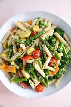 a white bowl filled with pasta and vegetables