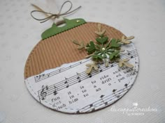 an ornament made out of sheet music with green leaves and musical notes on it