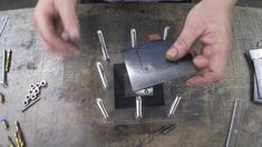 a person is making something out of metal and some screwdrivers on a table