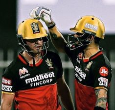 two men in yellow and black uniforms standing next to each other with their arms around one another