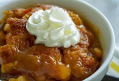 a close up of a bowl of food with whipped cream on top