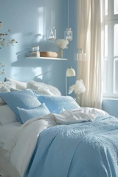 a bedroom with blue walls and white bedding in front of a window filled with flowers