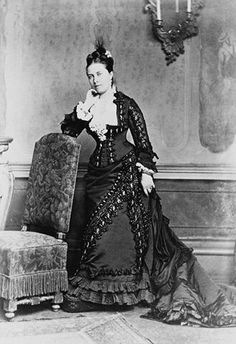 an old black and white photo of a woman sitting in a chair with her hand on her chin