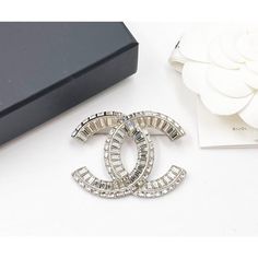 This is part of Chairish’s Costume Jewelry assortment.  Chanel Brand New Classic Silver CC Baguette Crystal Brooch  *Marked 23 *Made in Italy *Comes with the original box, pouch, booklet, camellia flower and ribbon *Brand New  -It is approximately 1.5" x 2". -Very pretty and classic Designer Silver Brooches For Evening, Luxury Silver Brooches, Designer Silver Brooches For Wedding, Designer Silver Wedding Brooches, Lapel Brooch, Chanel Brand, Box Pouch, Flower Iphone Wallpaper, Camellia Flower