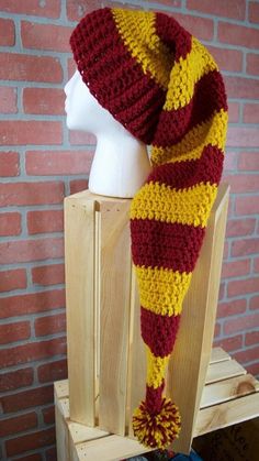 a knitted hat and scarf sitting on top of a wooden chair