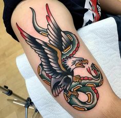 an eagle and snake tattoo on the arm