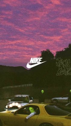 a yellow sports car parked in front of a purple and pink sky with the word nike on it