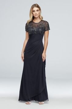 a woman wearing a long black dress with sheer shoulders and lace detailing on the top