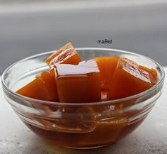 a glass bowl filled with orange cubes on top of a table