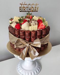 a birthday cake decorated with strawberries and chocolates