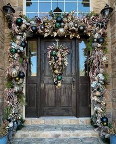 a front door decorated with ornaments and greenery