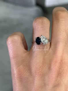 a woman's hand with a diamond and sapphire ring