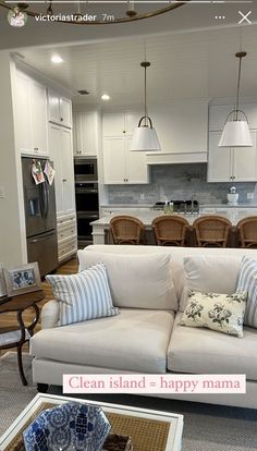 a living room filled with furniture next to a kitchen and dining room table in the background