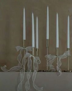 four white candles are lined up in a row