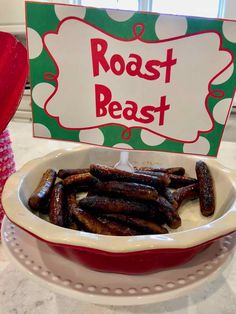 there is a red and white plate with hot dogs in it that says roast beast