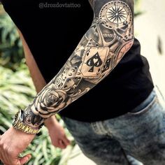 a man with a tattoo on his arm holding another mans hand