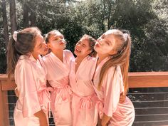 three girls in pink robes are standing together