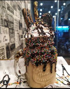 a cup filled with ice cream and sprinkles on top of a table