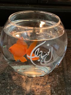 an orange fish in a bowl on a counter