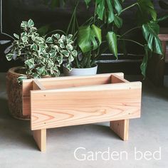 a wooden planter sitting next to a potted plant