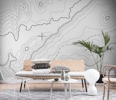 a living room filled with furniture next to a wall covered in abstract lines and shapes