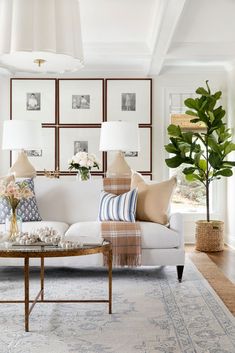 a living room filled with furniture and pillows on top of a white couch next to a window