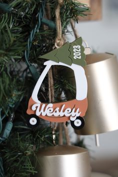 a christmas ornament hanging from the side of a tree with a name on it