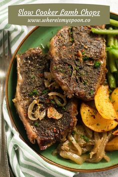 a green plate topped with steak, potatoes and asparagus next to a fork