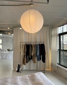 an empty room with clothes hanging from the ceiling