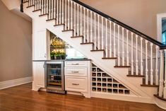 a wine rack under the stairs in a home