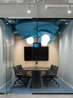 an office meeting room with glass walls and ceiling lights