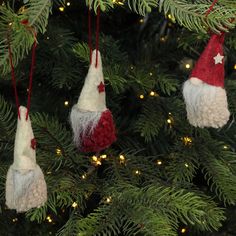 three ornaments hanging from a christmas tree in the shape of santa claus's hats