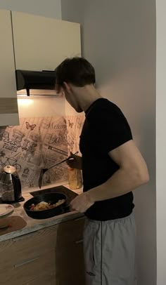 a man standing in front of a stove cooking food on top of a skillet