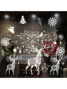 the window is decorated with christmas decorations and deers in snowflakes, trees, and baubles