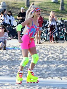 a woman riding roller skates on top of a sandy beach