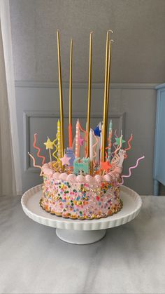 a birthday cake with candles and confetti on it