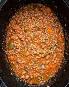 a pot filled with beans and carrots on top of a stove