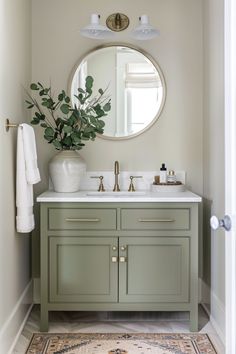 a bathroom with a sink, mirror and rug